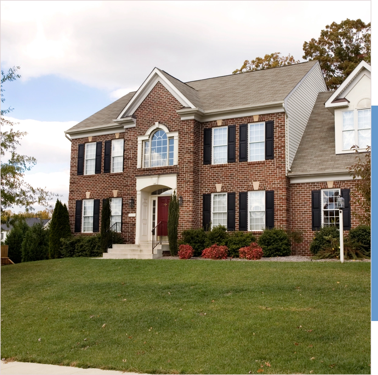 Brick two-story house with landscaping.